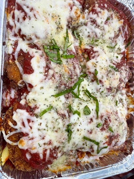 Baked pasta with melted mozzarella and basil