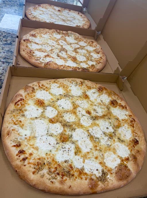 White pizzas boxed and ready to go