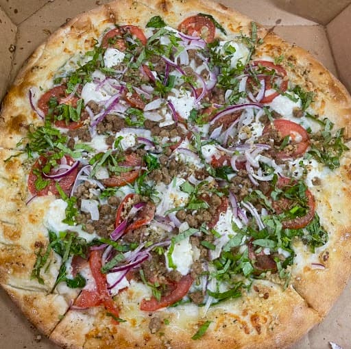 Pizza with arugula, tomato and red onion